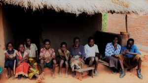 Elines Chunga, an elderly grandmother caring for her HIV+ daughter and nine children - three grandchildren and others are orphans from the area. Pictured here in front of their current old home, they received a new home thanks to support from Ekwendeni Hospital and PWS&D. Ian Persaud, IM mission staff (one month), treated Elines' daughter, Joyce, and she's now recovering very well.